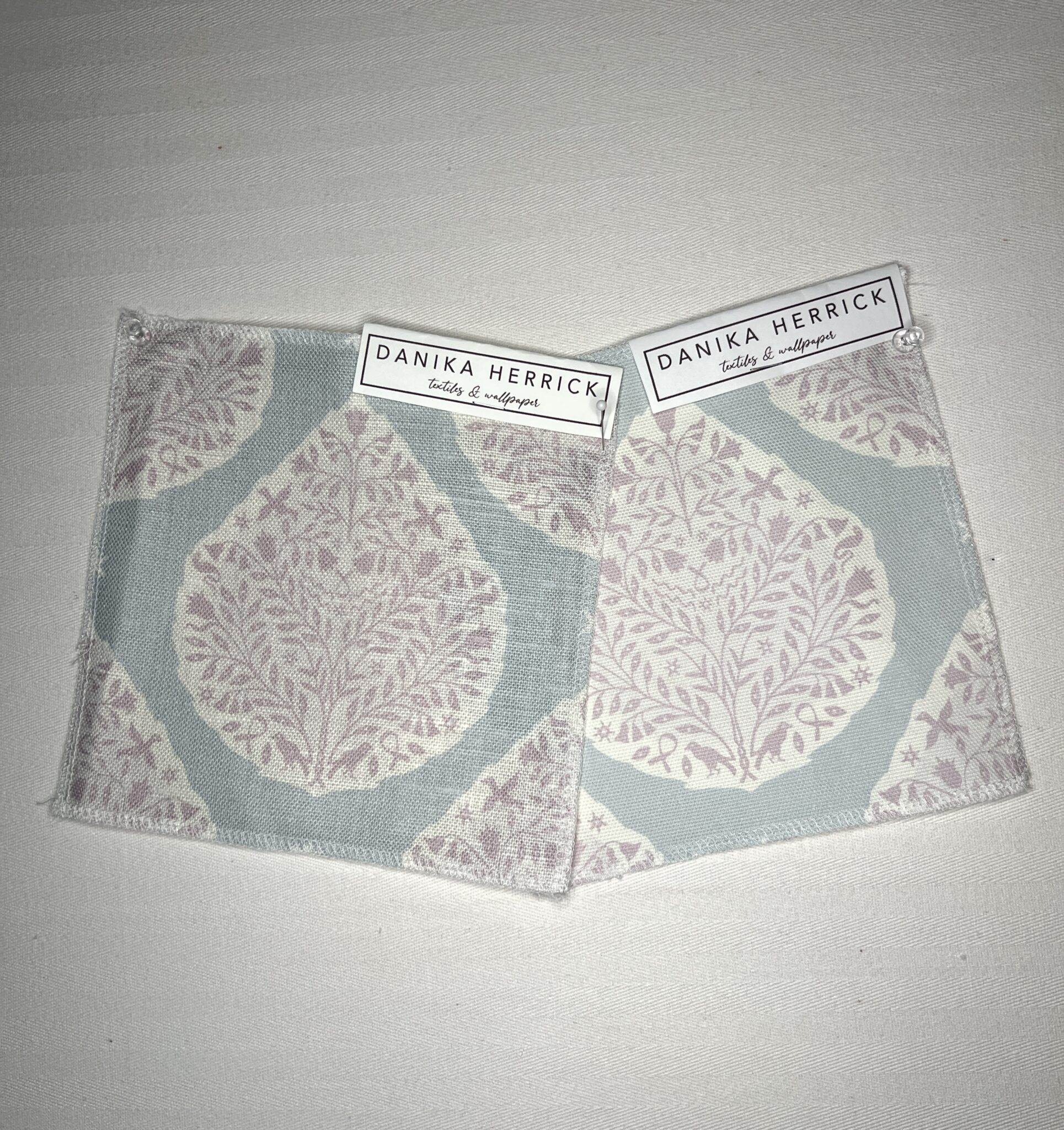 two swatches of paisley fabric under incandescent light