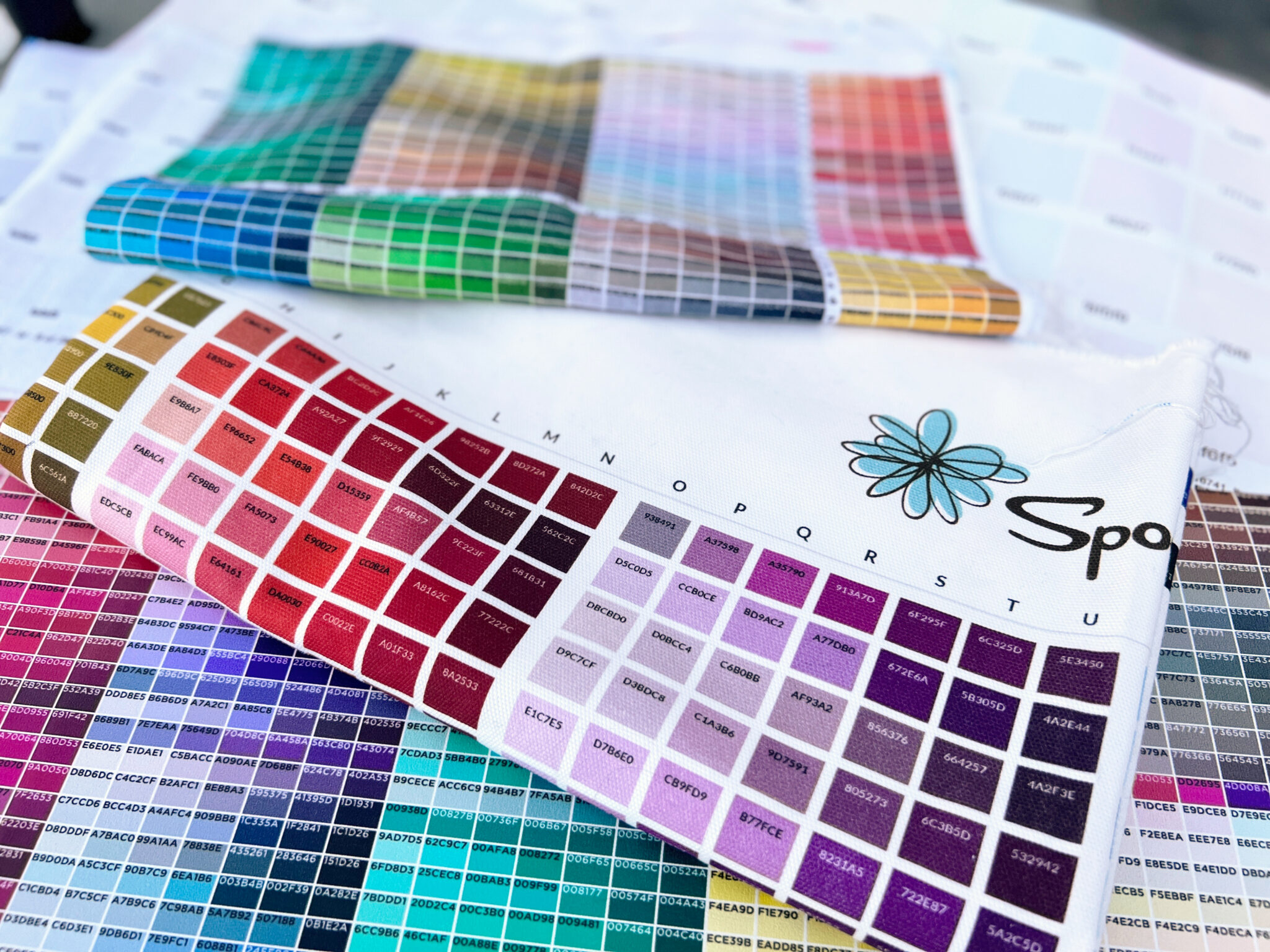 a variety of colored squares printed on fabric with corresponding hex codes