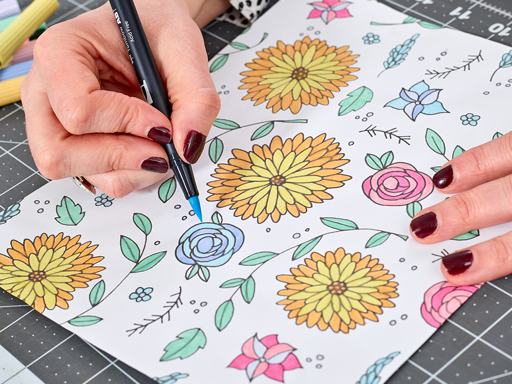 artist colors in the finished flower drawing with markers