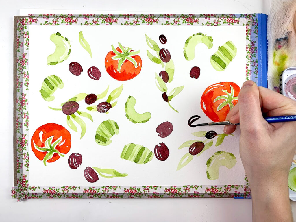 an artist adding olives to a watercolor painting of tomatoes and celery